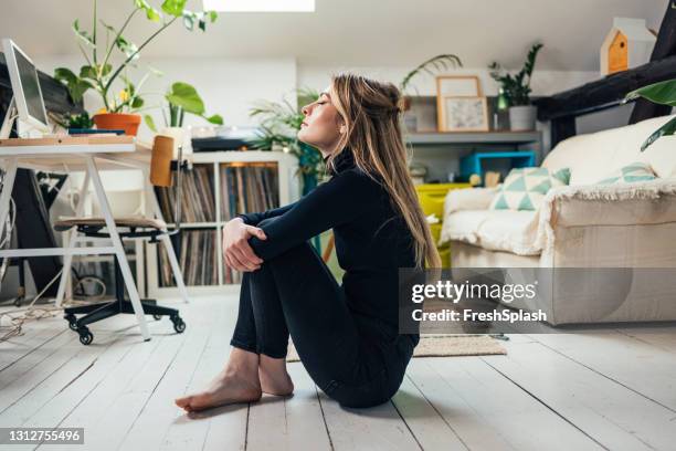 nuevo concepto normal: joven hermosa mujer caucásica pasando su tiempo libre solo en su apartamento estudio - inhaling fotografías e imágenes de stock