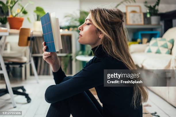 new normal concept: young beautiful caucasian woman spending her free time alone in her studio apartment - poet stock pictures, royalty-free photos & images