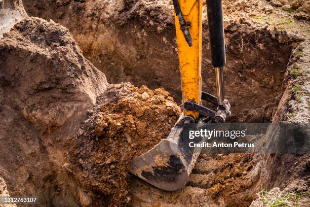 small excavator working on a construction site. construction works - baggerschaufel stock-fotos und bilder