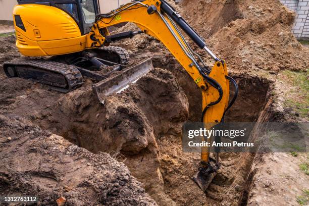 small excavator working on a construction site. construction works - pala meccanica foto e immagini stock