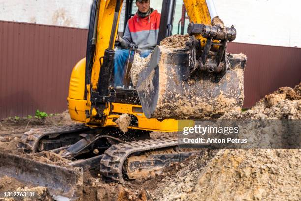 small excavator working on a construction site. construction works - digging bildbanksfoton och bilder