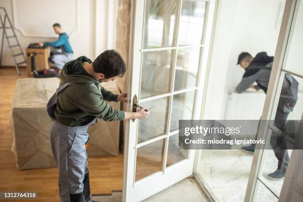 repairman repairing door knob on interior door - locksmith stock pictures, royalty-free photos & images