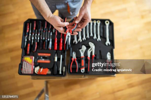 repairman taking pliers from toolbox - tenaz imagens e fotografias de stock