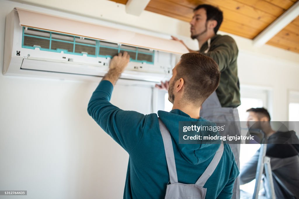 Equipo de reparadores instalando aire acondicionado