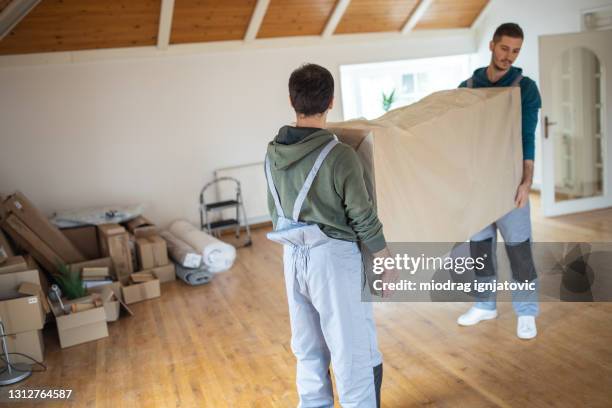 moving company workers bringing in furniture in house - moving service imagens e fotografias de stock