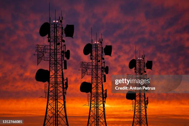 communication tower against the background of the sunset sky. communication concept - antennes photos et images de collection