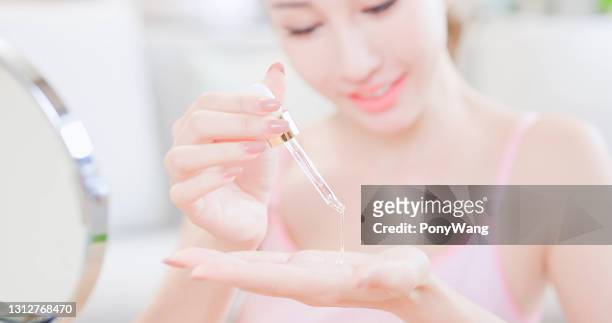 woman apply moisturizer in hand - dropper bottle stock pictures, royalty-free photos & images