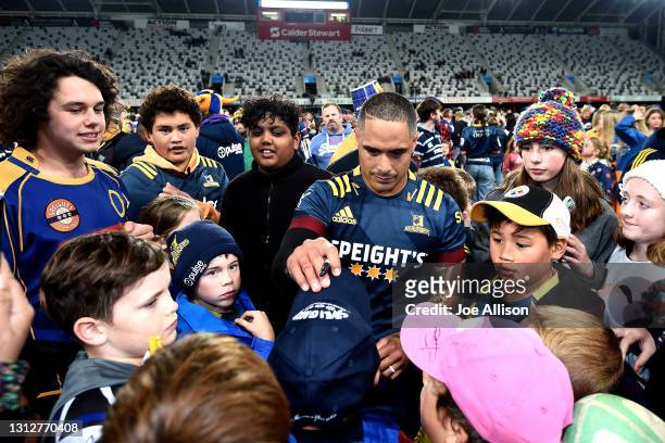 Aaron Smith of the Highlanders places a hat on the head of a fan during the round eight Super Rugby Aotearoa match between the Highlanders and the...