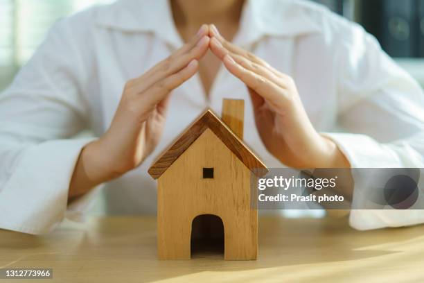 insurance protective businesswoman hand over house for protection and care, concept of home and real estate property insurance. - 庇護者 ストックフォトと画像