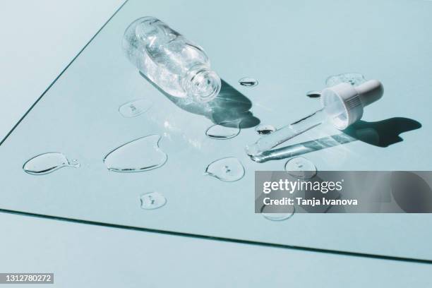 liquid gel and serum drops with glass bottle nearby pipette on blue background. beauty product with peptides, ceramides, hyaluron gel. - serum sample stock pictures, royalty-free photos & images
