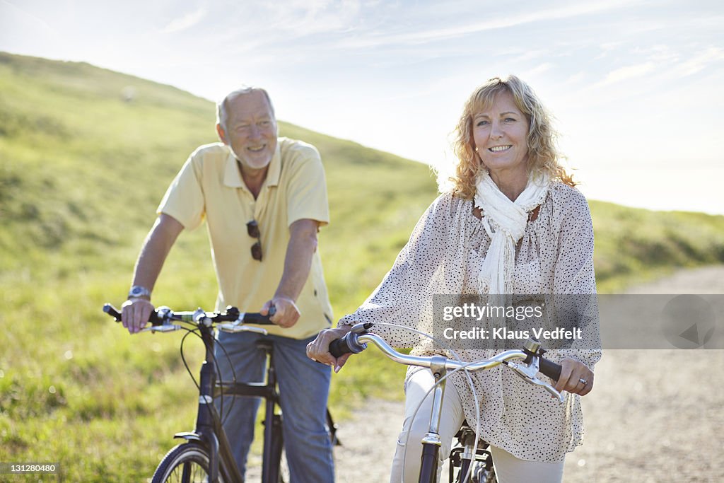 Mature couple bicycling on gravel road