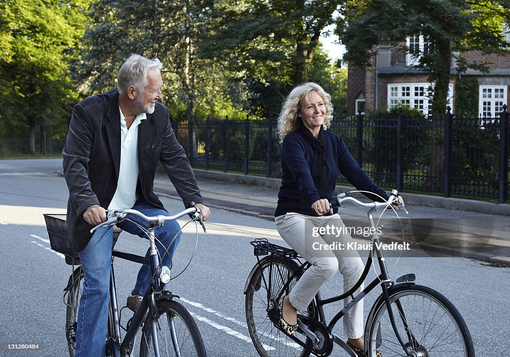 Mature couple cycling in residential neighborhood