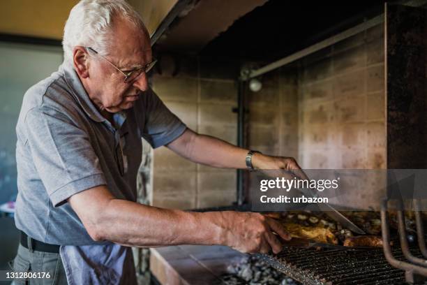 hombre mayor barbacoa carne en casa - argentina steak fotografías e imágenes de stock