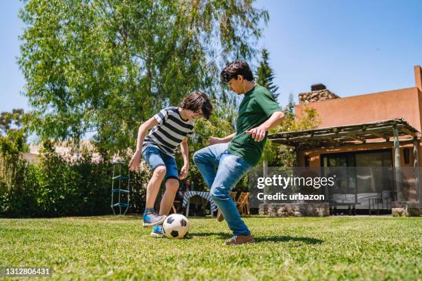 kinder, die im hinterhof fußball spielen - backyard football stock-fotos und bilder