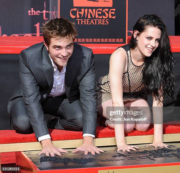 Robert Pattinson and Kristen Stewart pose at "The Twilight Trio" Hand/Foorprint Ceremony at Grauman's Chinese Theatre on November 3, 2011 in...