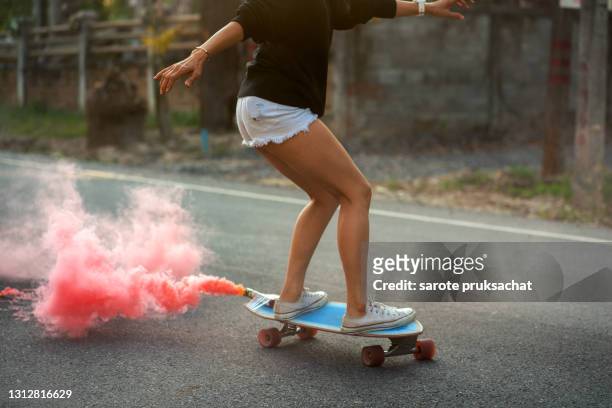 close-up asian women surf skate or skates board outdoors on beautiful summer day. - beautiful asian legs stock pictures, royalty-free photos & images