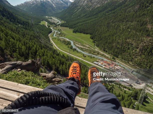 高い上のベンチで休んでいるフェラータ通りの男のpov - pov shoes ストックフォトと画像