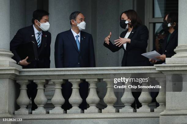 Vice President Kamala Harris and Japanese Prime Minister Yoshihide Suga look at the White House from a balcony of the Eisenhower Executive Office...