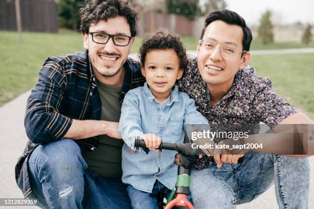 famiglia felice con due papà e figlio bambino - adoption foto e immagini stock