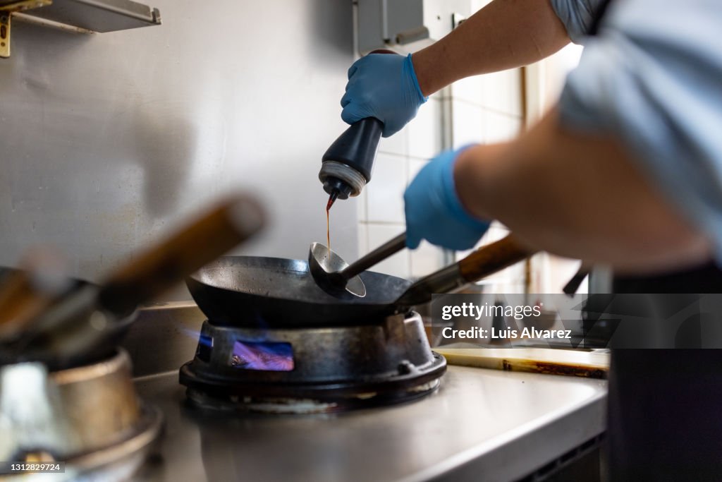 Closeup of chef hands preparing food on stove