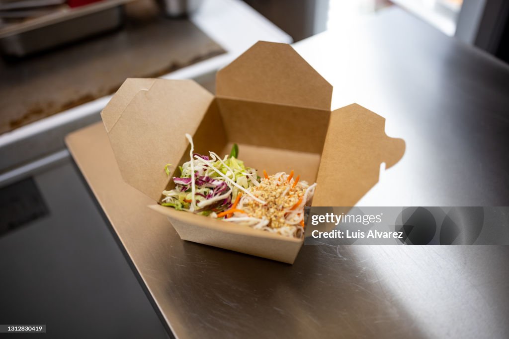 Preparing asian takeaway orders in restaurant kitchen