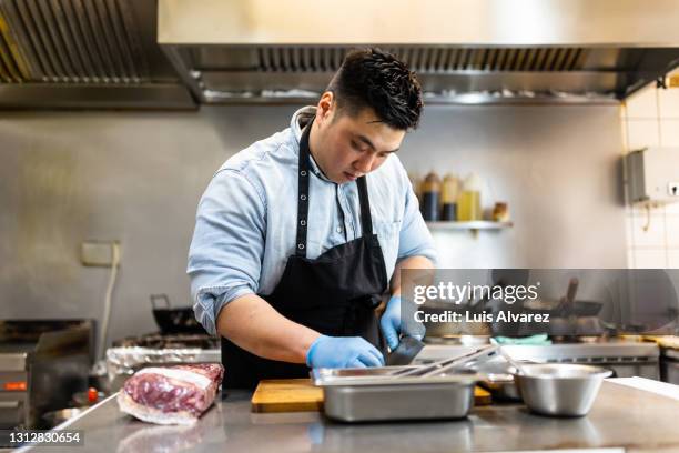asian man working in restaurant kitchen - different cuts of meat stock pictures, royalty-free photos & images