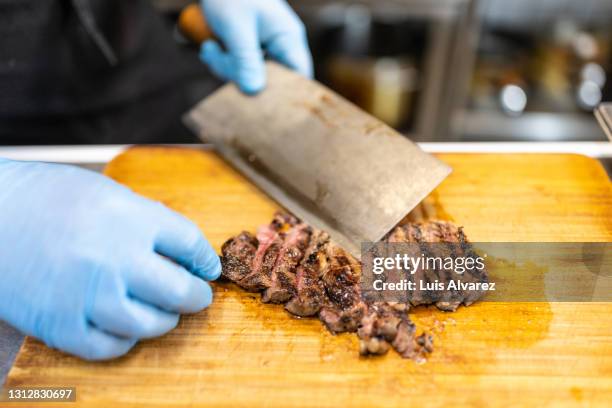 chef slicing roast beef using cleaver knife - blue steak stock pictures, royalty-free photos & images
