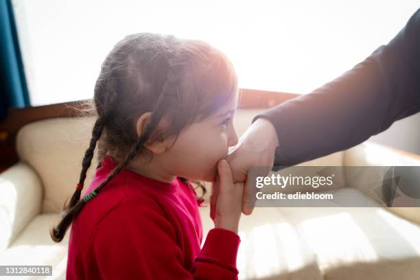 little girl kissing grandmather hand at religious festival - kissing hand stock pictures, royalty-free photos & images