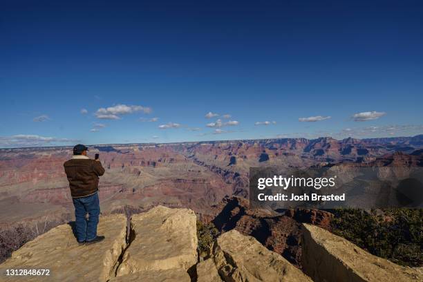 Tourist takes a photo from the view at Powell Point at the Grand Canyon on January 09, 2021 in Grand Canyon Village, Arizona.