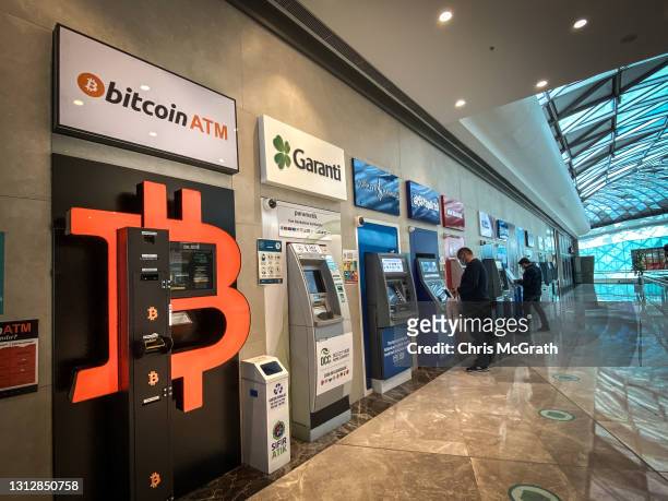 People use bank ATM"s next to a Bitcoin ATM machine at a shopping mall on April 16, 2021 in Istanbul, Turkey. Turkey's Central Bank announced a ban...