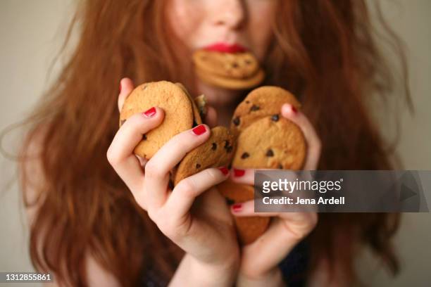 over eating, sugar addiction, overindulgence: woman with sugar addiction to junk food - gier stock-fotos und bilder