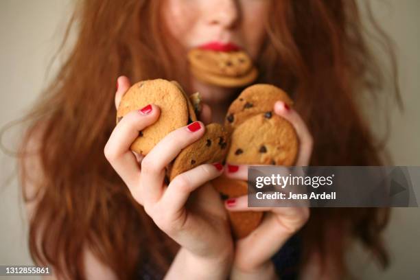 over eating, sugar addiction, overindulgence: woman with sugar addiction to junk food - over eating fotografías e imágenes de stock