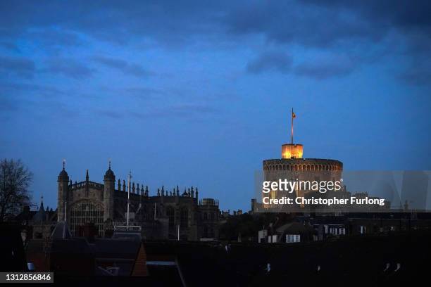 Union flag flies at half mast as nighttime falls over St George's Chapel and Windsor Castle, on the eve of the funeral of Prince Philip, Duke Of...