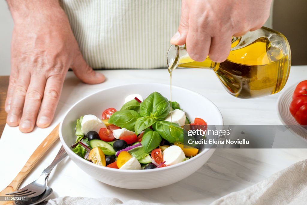 Fresh salad with cucumbers, tomatoes, onions, black olives and feta or mozzarella cheese, with olive oil and celery