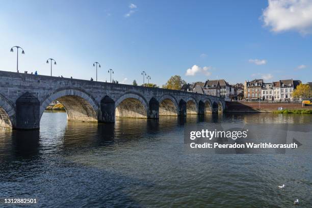 outdoor sunny view of sint servaasbrug, historical footbridge cross meuse river, and background of cityscape in maastricht, netherlands. - maastricht 個照片及圖片檔
