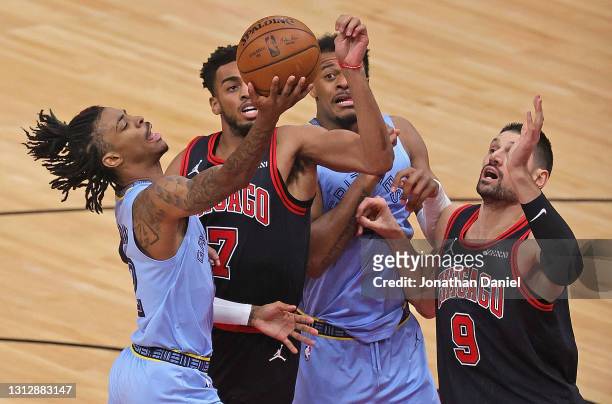 Ja Morant of the Memphis Grizzlies shoots against Troy Brown Jr. #7 and Nikola Vucevic of the Chicago Bulls at the United Center on April 16, 2021 in...
