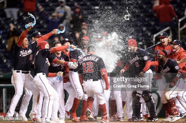 Kyle Schwarber of the Washington Nationals is doused with water by teammates after hitting a walk-off home run in the ninth inning against the...