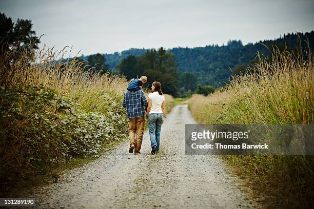 family walking on dirt road rear view - seattle people stock pictures, royalty-free photos & images