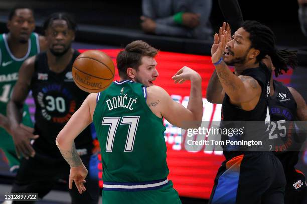 Luka Doncic of the Dallas Mavericks passes the ball against Derrick Rose of the New York Knicks and Reggie Bullock of the New York Knicks in the...