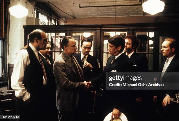 Abe Vigoda and Robert Duvall watch Marlon Brando and Al Lettieri shake hands in a scene from the film 'The Godfather', 1972.