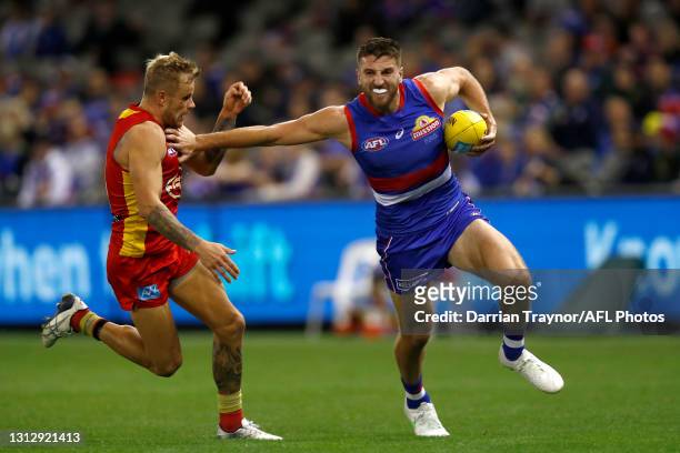 Marcus Bontempelli of the Bulldogs fends off Brandon Ellis of the Suns during the round five AFL match between the Western Bulldogs and the Gold...