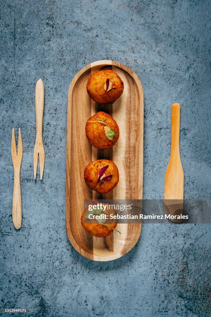 Iberian ham croquettes, served on a wooden base