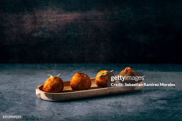 iberian ham croquettes, served on a wooden base - kroket stockfoto's en -beelden