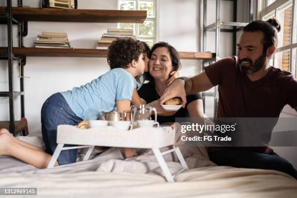 family waking up mother and serving her breakfast in bed - mother's day breakfast stock pictures, royalty-free photos & images