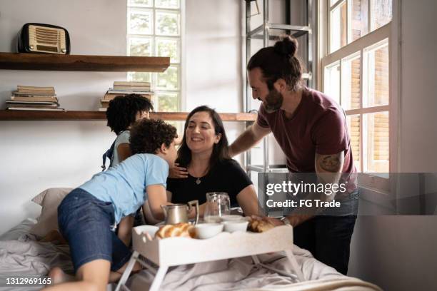 family waking up mother and serving her breakfast in bed - mother's day breakfast stock pictures, royalty-free photos & images