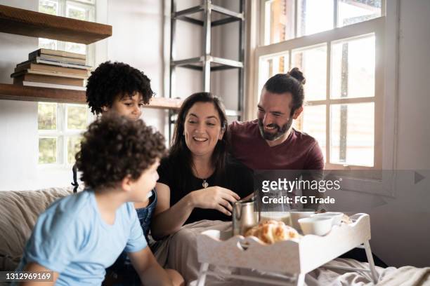 family waking up mother and serving her breakfast in bed - mother's day breakfast stock pictures, royalty-free photos & images