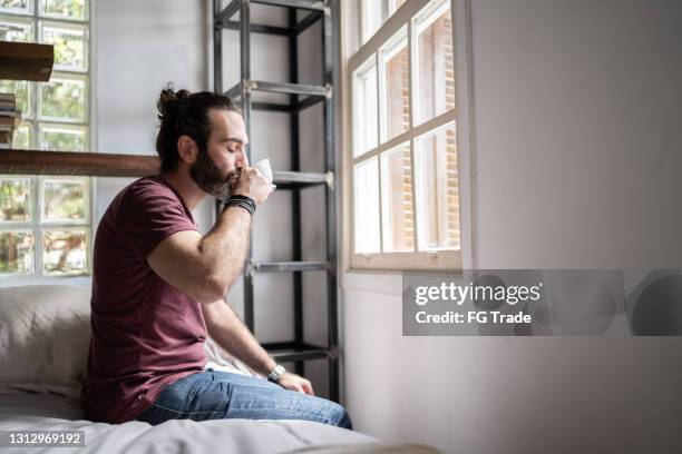 man drinking coffee sitting in the bed at home - bed side view stock pictures, royalty-free photos & images