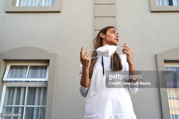 young girl in white medical mask outdoors in afternoon - mask street style stock pictures, royalty-free photos & images