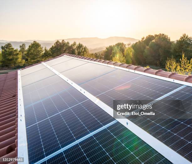 sonnenkollektoren auf dem dach eines hauses bei sonnenuntergang - control panel stock-fotos und bilder