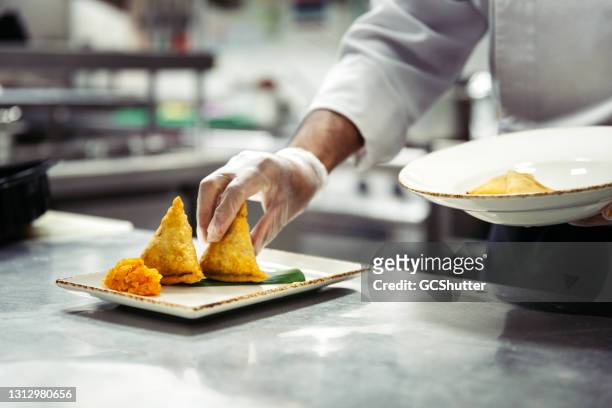 chef platting gemüse samosa - indian cuisine stock-fotos und bilder
